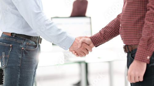 Businessmen making handshake in an office.