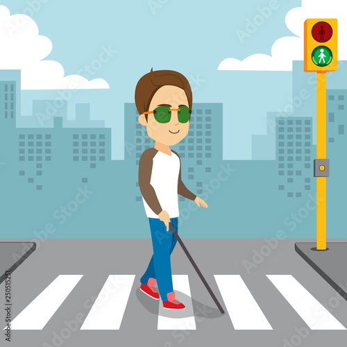 Blind man holding white cane walking pedestrian crossing with green traffic light