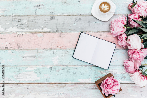Fototapeta Naklejka Na Ścianę i Meble -  Flat lay home office desk.Pink peony bouquet, coffee and notebook on wooden background.Top view feminine. Flat lay home office desk. Woman workspace