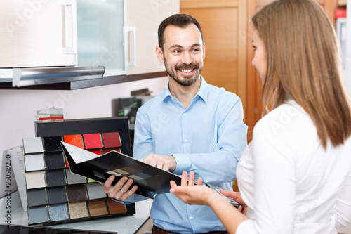 Competent seller consulting female customer in store of kitchen furnishing and appliances photo