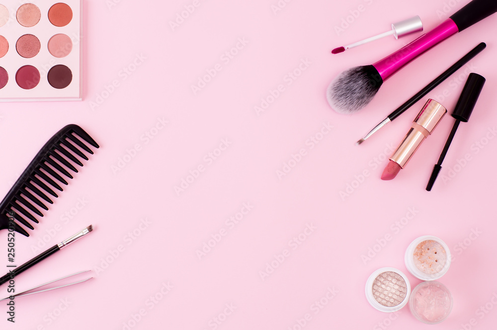 Fototapeta Makeup products and tools on a pink background. Frame of decorative cosmetics and accessories