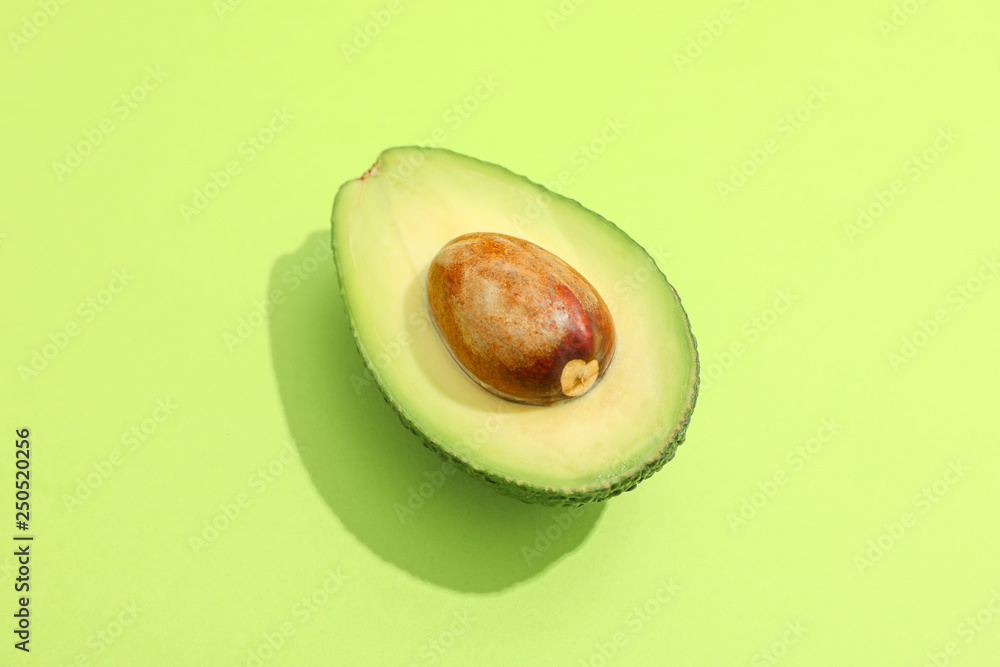 Half of avocado on color background, space for text