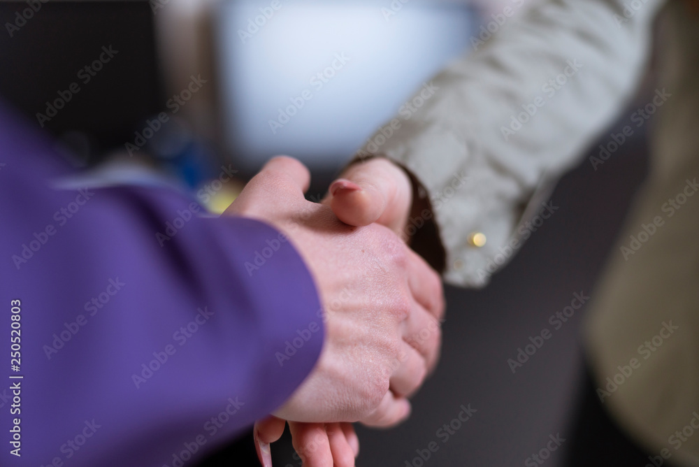 Man and woman handshake, only arms visible Man and woman handshake, only arms visible