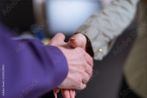 Man and woman handshake, only arms visible