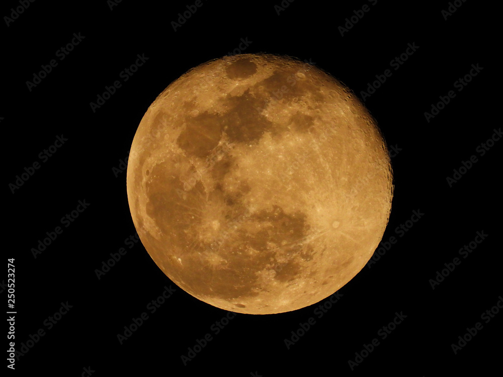 Extreme zoom photo of redish full moon as seen in deep darkness Extreme zoom photo of redish full moon as seen in deep darkness