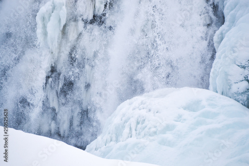 Icelandic Iceland waterfall frozen and covered in snow during winter © Dan