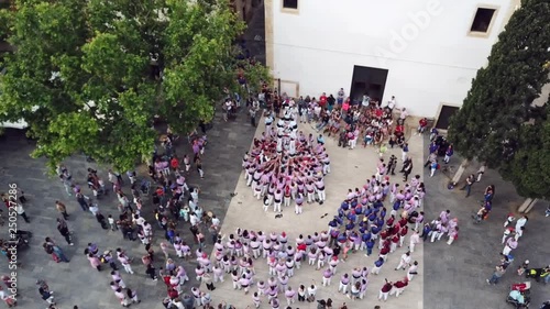 wonderful upper view castellers climb down from human pyramid at training session on square in Tarragona photo