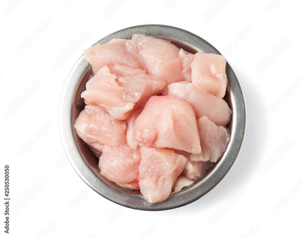 Fresh, raw pet food. Pieces of chicken fillet in a metal bowl, isolated on a white background. Top view. Fresh, raw pet food. Pieces of chicken fillet in a metal bowl, isolated on a white background. Top view.