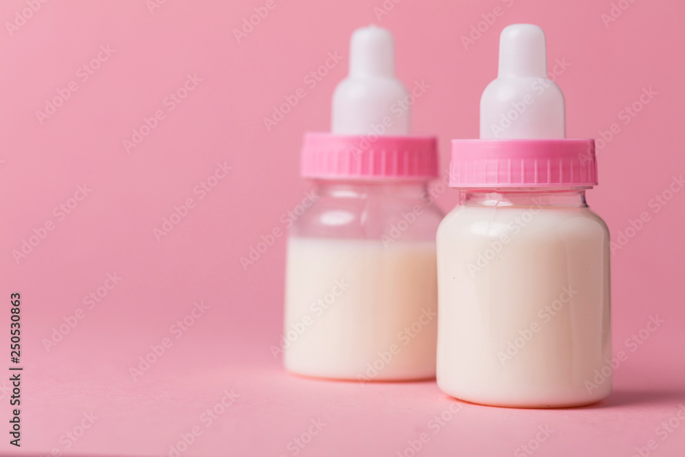 Baby bottle full of milk on a pink background Baby bottle full of milk on a pink background