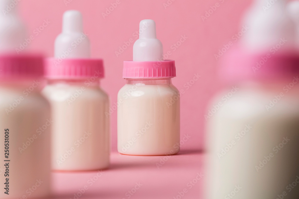 Baby bottle full of milk on a pink background Baby bottle full of milk on a pink background
