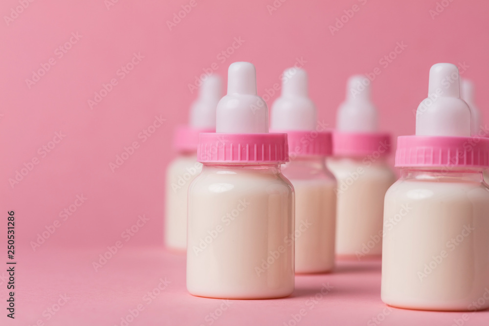 Baby bottle full of milk on a pink background Baby bottle full of milk on a pink background