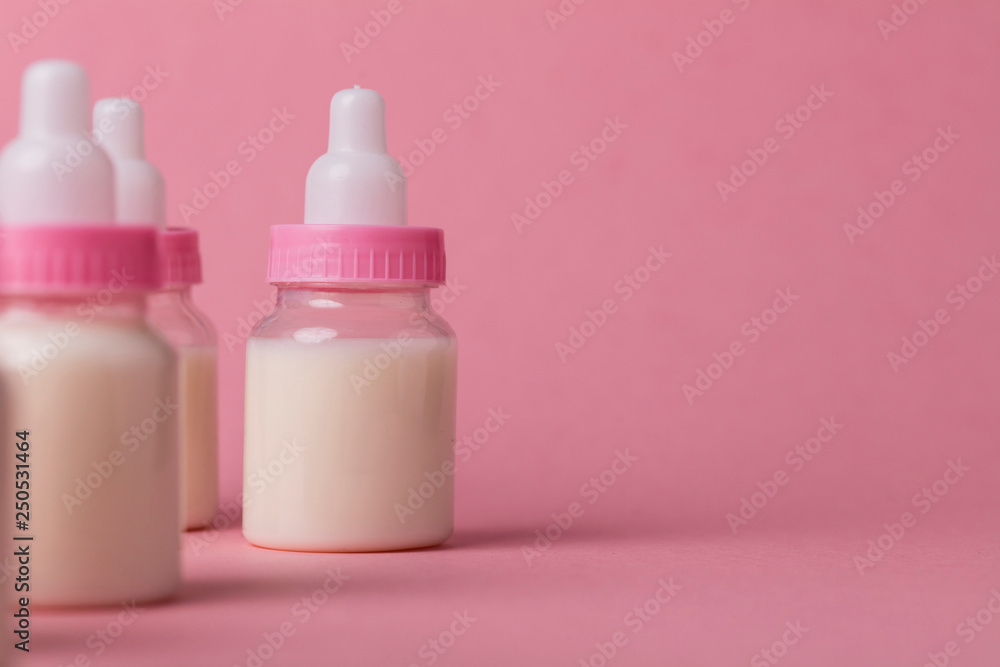 Baby bottle full of milk on a pink background Baby bottle full of milk on a pink background