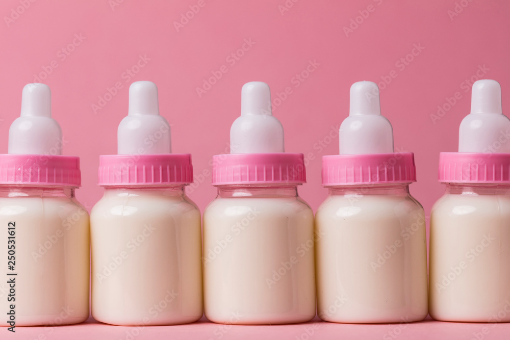 Baby bottle full of milk on a pink background Baby bottle full of milk on a pink background