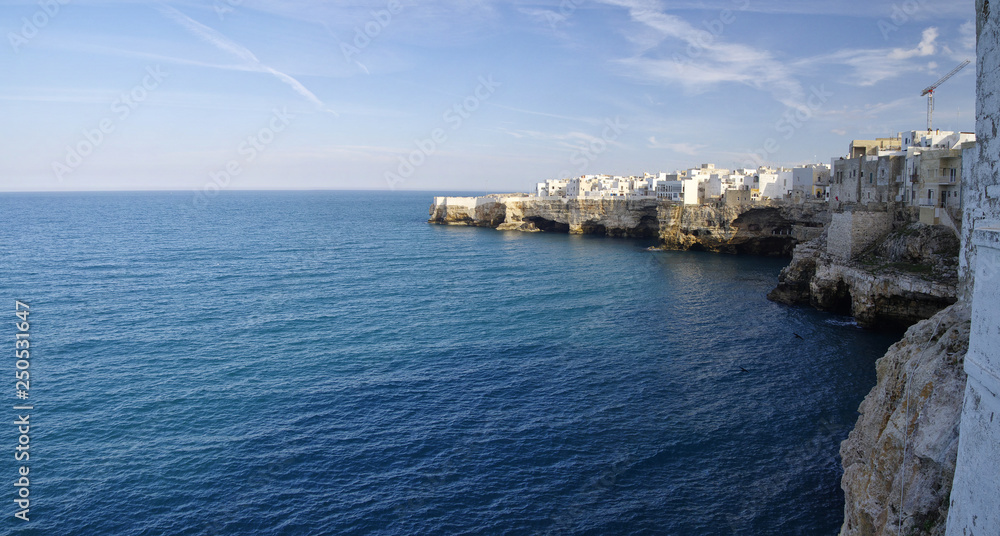 Suggestive landscape view on dramatic cliffs with caves rising from Adriatic sea in Polignano a Mare, Puglia, Italy.