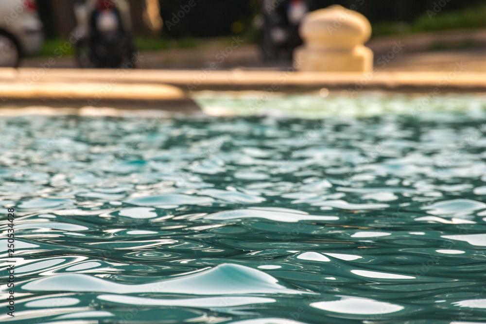 Closeup of a water fountain - water, ripples, splash and a cool color of blue. Background, refreshing. This fountain is found in Rome Italy Trastevere neighborhood in the park above the city