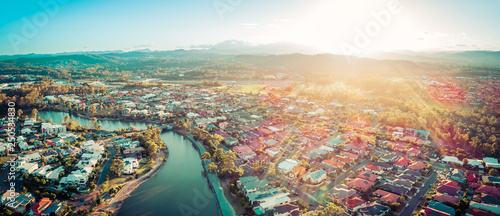 Aerial panorama of beautiful sunset with sun flare over luxury suburb on the Gold Coast, Queensland, Australia photo