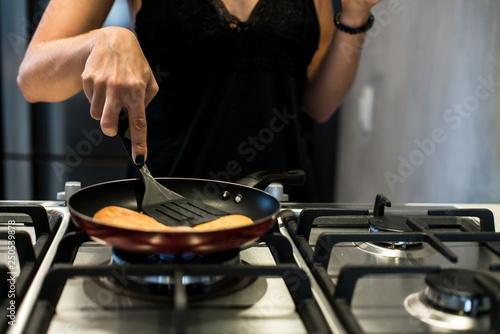 Young woman making french bread in frying pan
