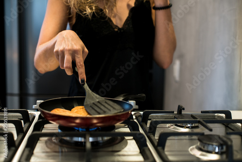 Young woman making french bread in frying pan