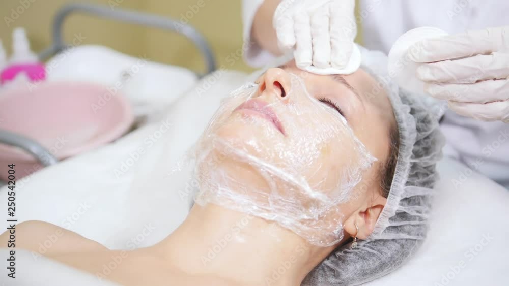 Cosmetologist cleans client's face doing cosmetic procedures of mesotherapy in cosmetology clinic. Cosmetologist cleans client's face doing cosmetic procedures of mesotherapy in cosmetology clinic.