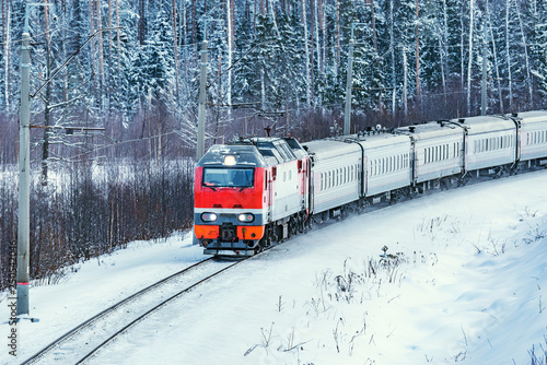 Passenger train approaches to the station at cold winter morning time. Fryazevo. Moscow region. Russia.