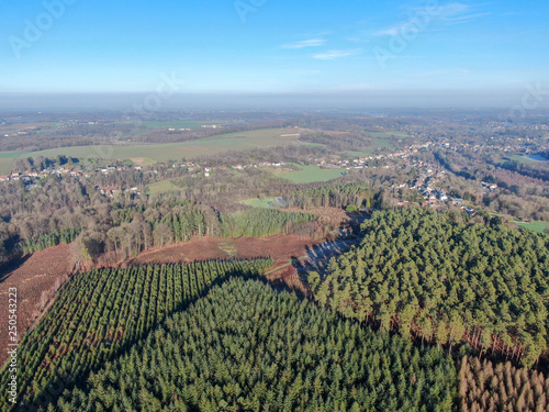 Aerial view of countryside landscape with forests and farmlands during beautiful winter day in the morning. Belgium, Walloon Brabant