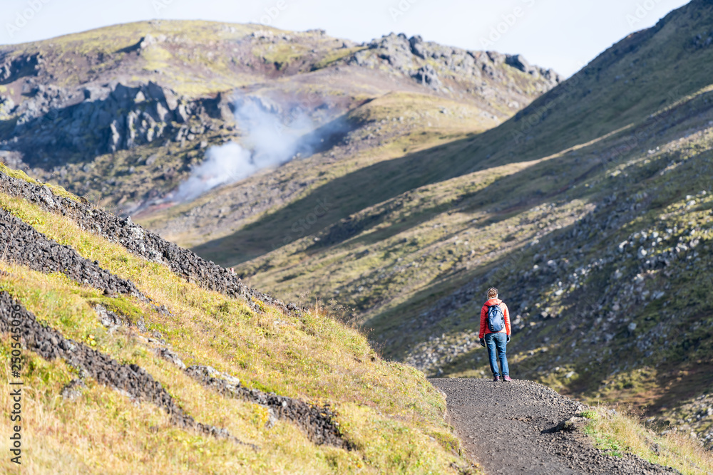 Reykjadalur, Iceland Hveragerdi Hot Springs road footpath with steam during autumn landscape morning in golden circle with people woman on hiking trail
