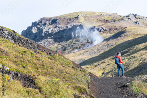 Reykjadalur, Iceland Hveragerdi Hot Springs road footpath with steam during autumn landscape morning in golden circle with people woman standing on hiking trail