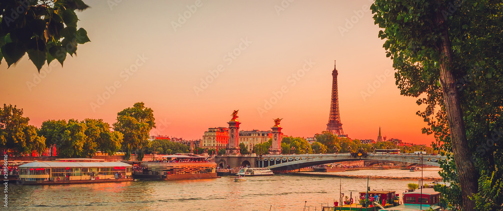 Sunset view of Eiffel Tower, Alexander III Bridge and river Seine in Paris, France.