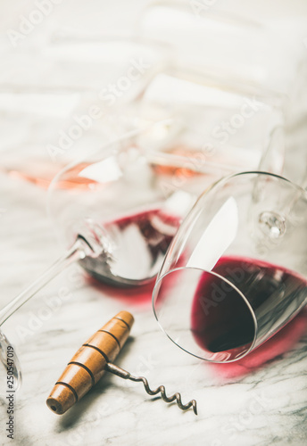 Red and rose wine in glasses and corkscrew over grey marble background, selective focus . Wine bar, winery, wine degustation concept photo