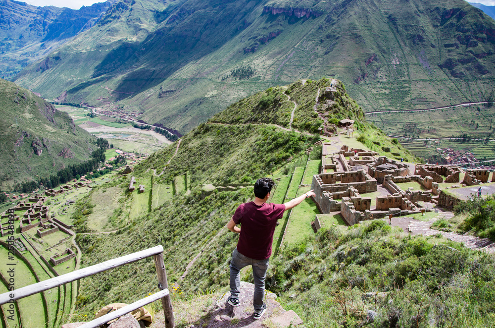 Tourist exploring the Inca Trails leading to the ruins of Pisac, Sacred Valley, major travel destination in Cusco region, Peru. Vacations and adventures in South America.