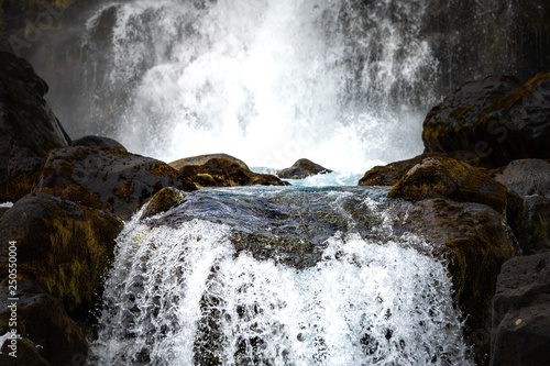 Thingvellir National Park Oxararfoss waterfall rocky abstract closeup landscape on Golden Circle in South Iceland with water flowing on rocks from cliff photo