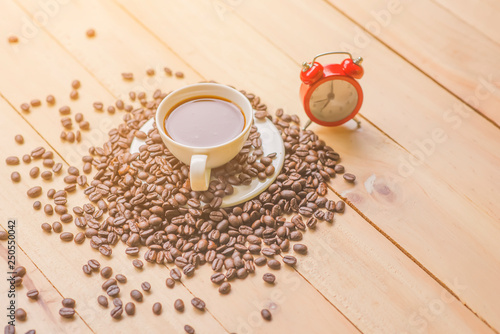 Cup of coffee white notebook  pencil  coffee beans on a Desktop from wooden plank.