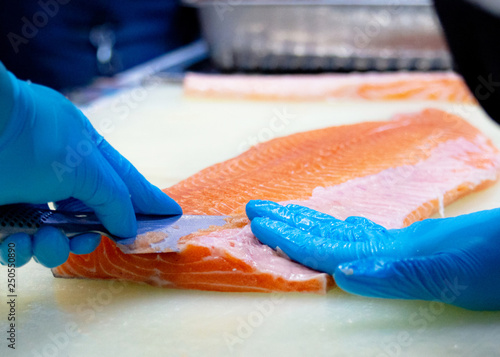 chef slicing raw fresh salmon, Chef preparing a fresh salmon on a cutting board