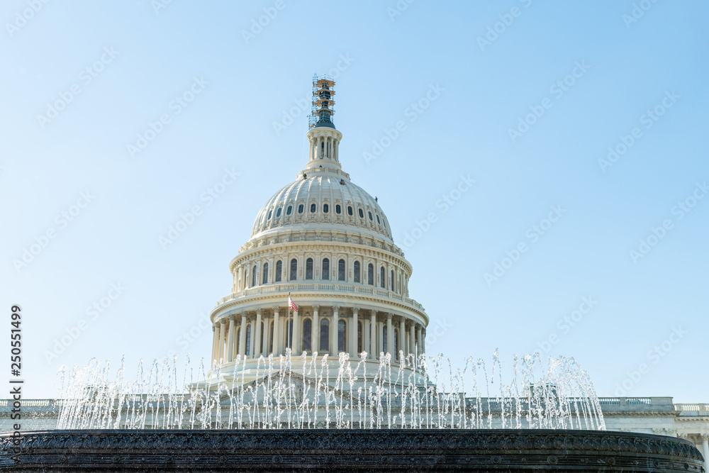 US Congress dome with water fountain splashing and American flag waving in Washington DC, USA on Capital capitol hill with columns pillars and nobody
