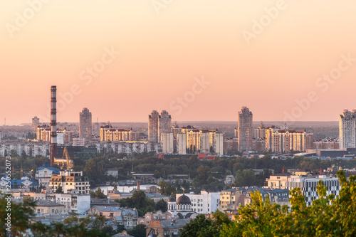 Kyiv, Ukraine cityscape skyline of Kiev downtown area during colorful orange sunset and power plant with old apartment buildings in eveniing