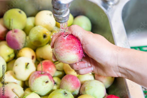 Photography Many green yellow or pink lady apples or sink with hand washing one faucet showi