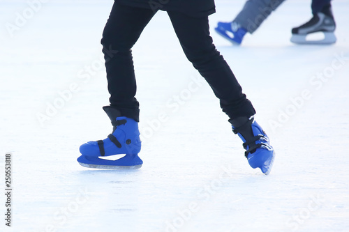 Feet of people skating on the ice rink