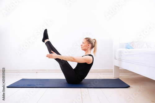 Wallpaper Mural Young and fit girl doing yoga asana next to the bed in the bedroom. Yoga and health concept. Torontodigital.ca