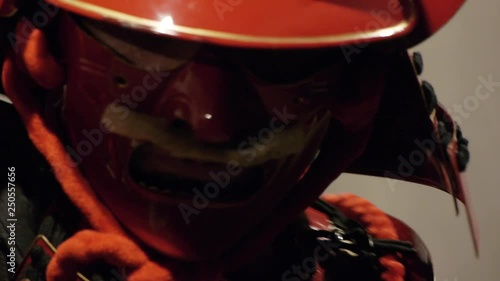 samurai in red helmet doing exercises with a katana sword