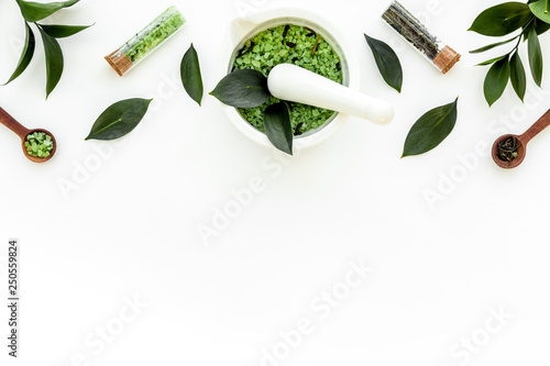 Make cosmetics with tea tree essential oil. Fresh tea tree leaves, mortar and pestel, cosmetics on white background top view border copy space