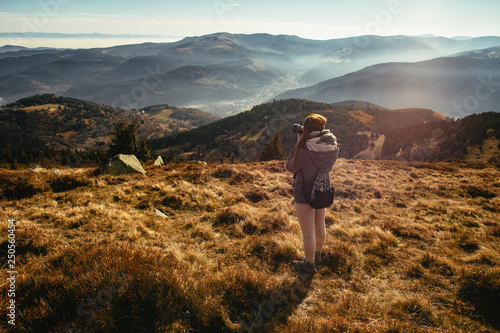 Young woman taking picture of a foggy valley