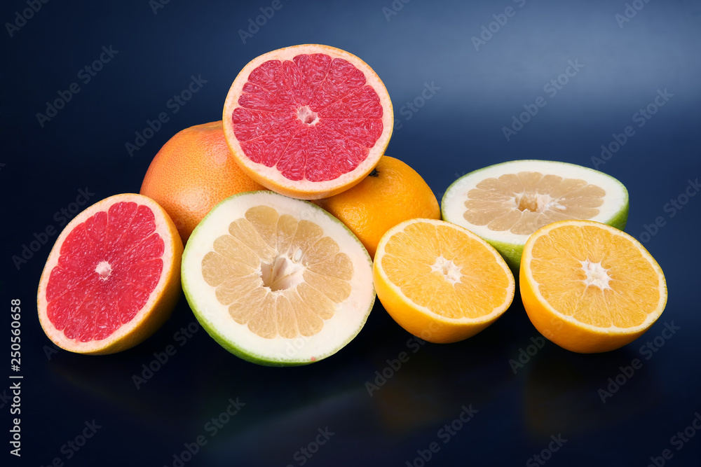 cut pieces of different citrus fruits on dark background cut pieces of different citrus fruits on dark background