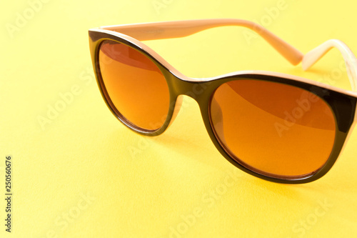 Sunglasses on yellow background. The concept of summer.