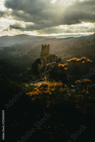 Lightbeam shining on medieval tower ruins built on a rock