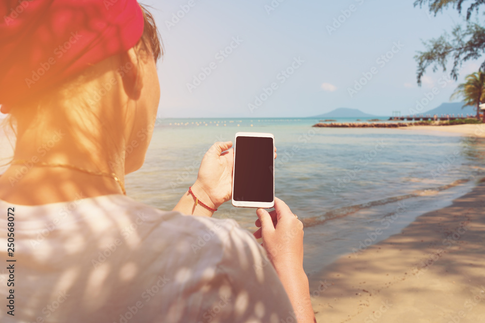 woman using mobile phone on the beach