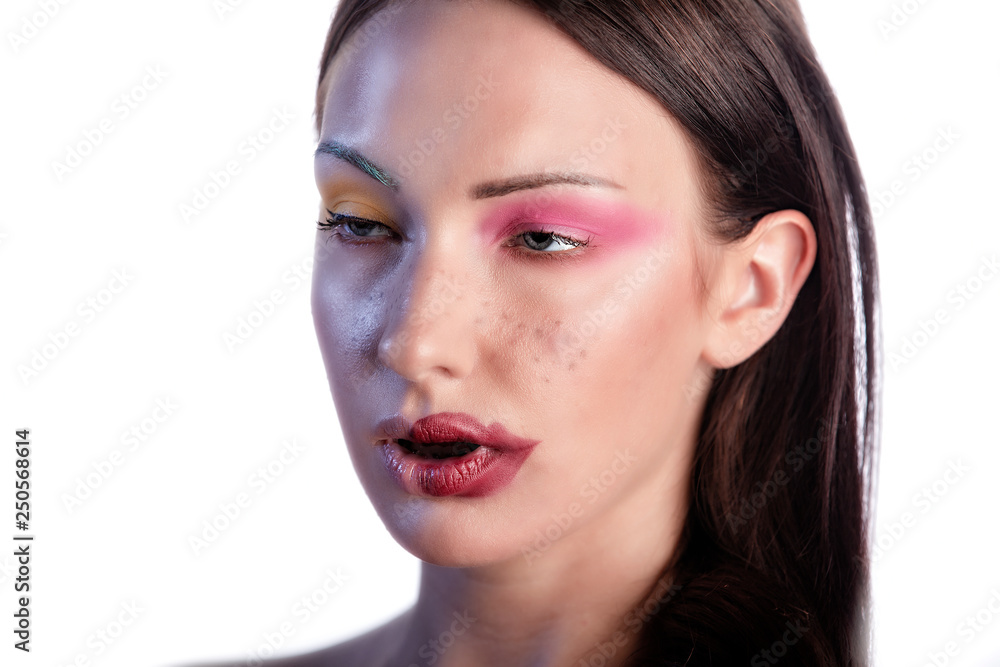 Young Caucasian Polish beauty model wears stunning cosmetics make-up that shows her stunning lips and bright colorful eye shadow in the studio . while she makes a funny face Young Caucasian Polish beauty model wears stunning cosmetics make-up that shows her stunning lips and bright colorful eye shadow in the studio . while she makes a funny face