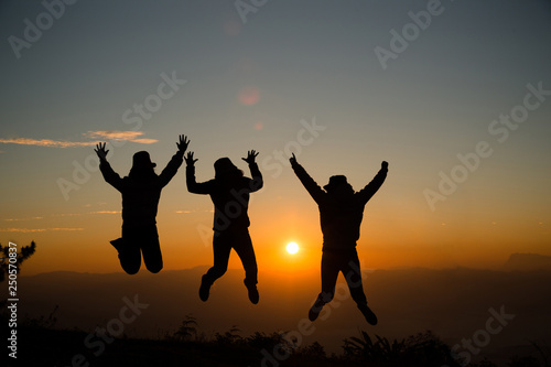 Group of happy young people jumping on the hill. Young women enjoying on their holiday outdoors.