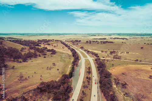 Aerial view of cars and trucks driving on Hume Highway among Australian countryside. photo