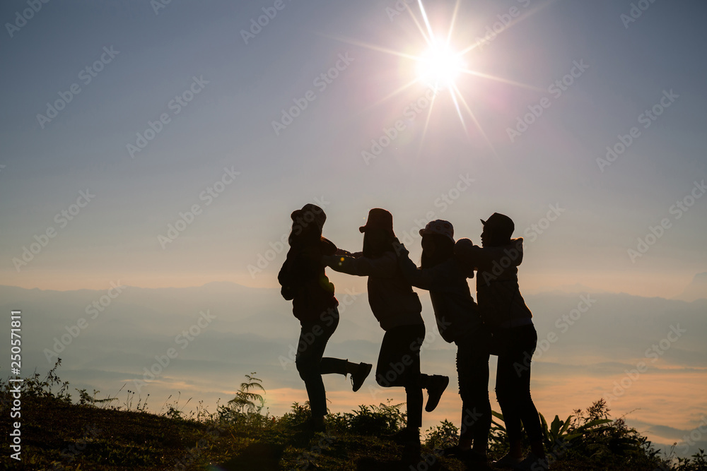Group of happy people playing at summer sunrise in nature.