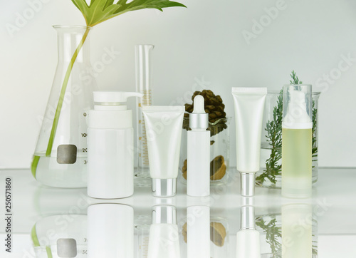 Obraz na płótnie Cosmetic and skincare bottle containers with green herbal leaves, Blank label package for branding mock-up, Natural organic beauty product research and development concept. w salonie